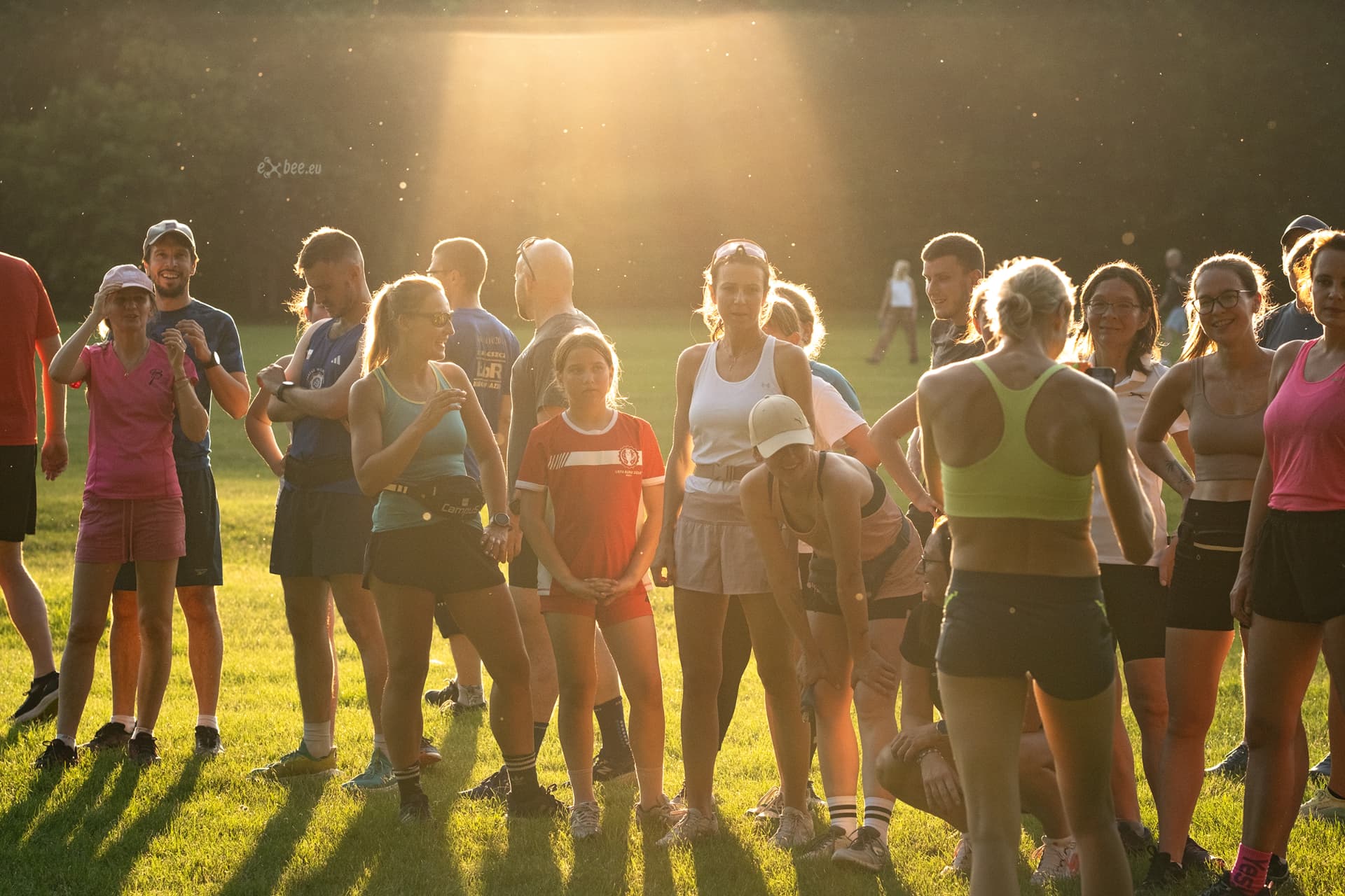 Uczestnicy Run Clubu na łące o zachodzie słońca