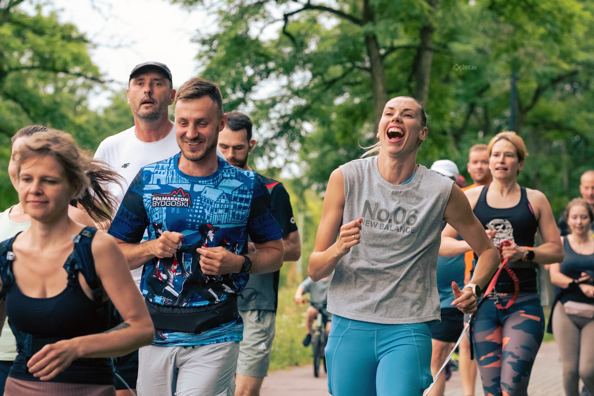 Uśmiechnięci biegacze podczas wspólnego biegu w parku